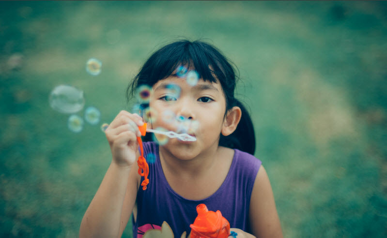 Child blowing bubbles - representing hope and joy